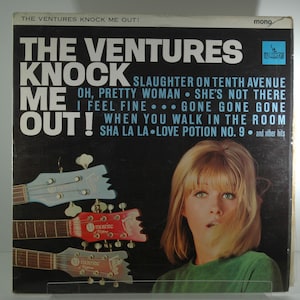 May include: A vintage vinyl record cover featuring The Ventures band with a photo of a woman with blonde hair and a green shirt. The album title is "The Ventures Knock Me Out!" and includes song titles like "Slaughter on Tenth Avenue", "Oh, Pretty Woman", "She's Not There", "I Feel Fine", "Gone Gone Gone", "When You Walk in the Room", and "Sha La La Love Potion No. 9".