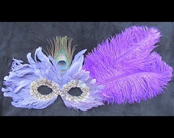 Purple Ostrich plumes sweep back from a purplish feather mask ready to wear for Halloween or any masked event.
