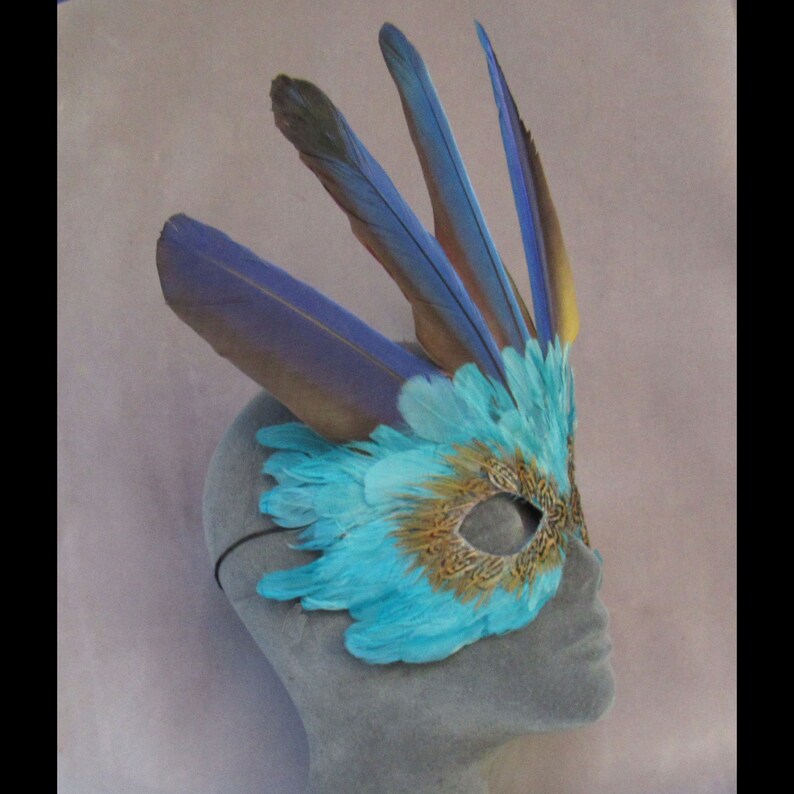 Turquoise Feather Mask Crowned by Macaw Feathers to become a fantasy character at a party or parade