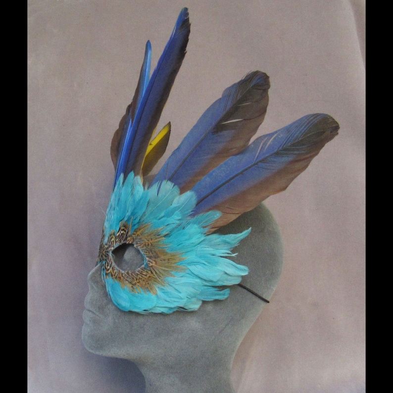 Turquoise Feather Mask Crowned by Macaw Feathers to become a fantasy character at a party or parade