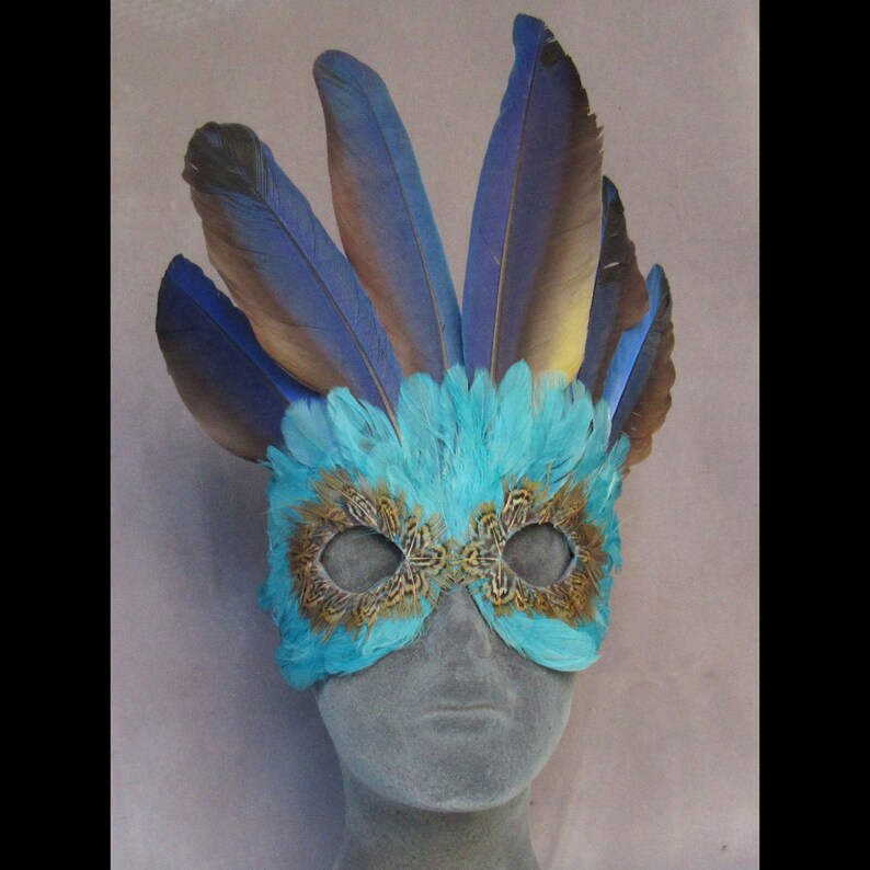 Turquoise Feather Mask Crowned by Macaw Feathers to become a fantasy character at a party or parade