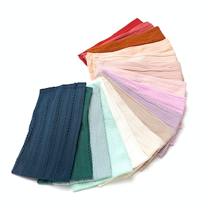 May include: A set of 14 fabric headbands in various colors, including navy blue, green, light blue, mint green, cream, beige, light pink, lavender, and brown. The headbands are made of a textured fabric with a cable knit design.