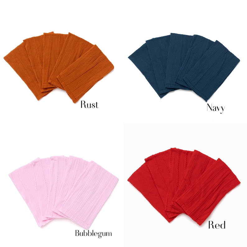 May include: Set of six fabric headbands in four colors: rust, navy, bubblegum pink, and red. The headbands are made of a textured fabric and are folded in a fan shape.