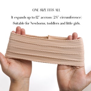 May include: A beige stretchy headband with a ribbed texture. It expands up to 12 inches across and has a 24 inch circumference.  "ONE SIZE FITS ALL" and "Suitable for Newborns, toddlers and little girls." are written in black text.