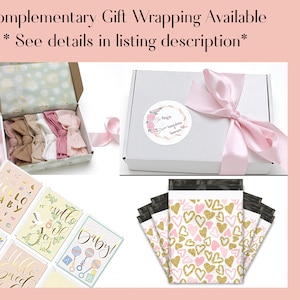 May include: An assortment of baby-themed items, including headbands, greeting cards, and gift boxes. The image features a white box tied with a pink ribbon, a box with headbands, and cards with the text "Hello Baby".