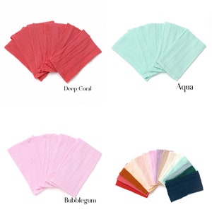 May include: A set of 10 fabric headbands in various colors, including deep coral, aqua, and bubblegum pink. The headbands are made of a soft, textured fabric and are arranged in a fan shape.