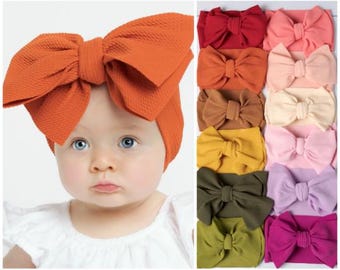 May include: A set of 10 colorful fabric headbands with large bows. The headbands are made of soft, stretchy fabric and are perfect for adding a touch of style to any outfit.