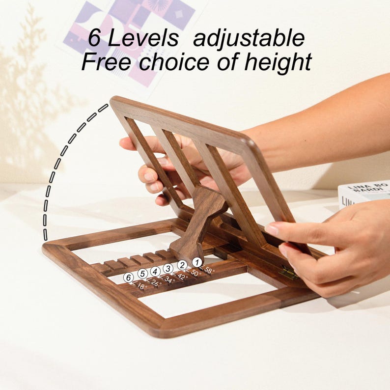 May include: A wooden adjustable book stand with six height levels. The stand is brown and features the text "6 Levels adjustable Free choice of height". The stand is being adjusted by a person's hands.