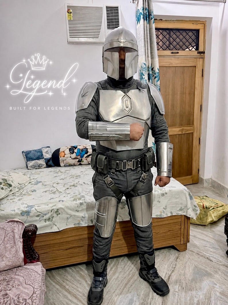 May include: A full-body costume resembling a character from a science fiction series. The costume features a silver helmet, chest plate, and arm guards over a dark gray jumpsuit. The text "Legend Built for Legends" is visible.