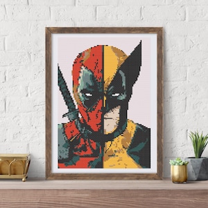 May include: Framed cross-stitch art featuring a split portrait of Deadpool and Wolverine. The artwork is in a pixelated style, with Deadpool's side in red and green, and Wolverine's in yellow and black. The frame is a warm brown.