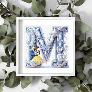 May include: A square white frame containing a cross-stitch pattern of the letter M, decorated with intricate blue and silver floral filigree. The design features a small, detailed depiction of the Beast and Belle in her yellow gown.