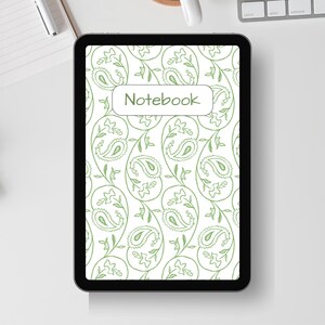 May include: A digital tablet displaying a notebook cover with a white background and a green paisley pattern. The word "Notebook" is in a white rectangle. The tablet is on a white desk with a pen, notepad, and keyboard.
