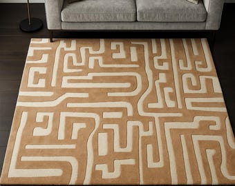 Peut inclure: Tapis rectangulaire avec un motif géométrique en tons beige et crème. Le tapis est placé devant un canapé gris avec deux coussins. Un lampadaire noir est à gauche du canapé.