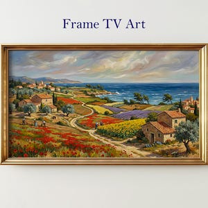 May include: A framed landscape painting in a gold-coloured frame. The artwork shows a coastal scene with houses, fields of red poppies, sunflowers, and lavender, and a blue ocean under a cloudy sky. Text at the top reads "Frame TV Art."