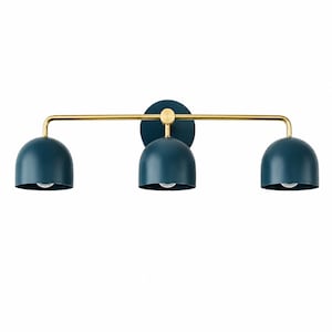 Op de afbeelding: Een wandlamp met drie lichtpunten, voorzien van een horizontale messing stang en een ronde, donkerblauwe wandbevestiging. Drie koepelvormige, donkerblauwe kappen zijn aan de stang bevestigd, elk met een enkele gloeilamp erin verwerkt.