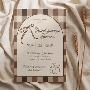 May include: Thanksgiving dinner invitation with a brown plaid border. The invitation features a decorative bow, the words "Thanksgiving Dinner," and the date, November 22nd, at 12 PM. The address is 89 Pumpkin Pie Lane, Cranberry Cove, Maine.