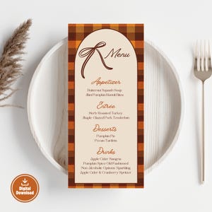 May include: A menu card with a fall theme, featuring a brown and orange plaid border. The menu lists appetizers, entrees, desserts, and drinks. The words "Digital Download" are in the lower left corner. The menu is on a white plate with a fork.