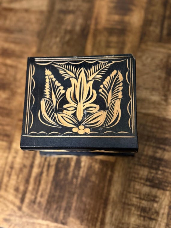 A hand-carved Romanian wooden puzzle box with no key — you have to figure out the secret mechanism to open it, and it can be personalized with a name.