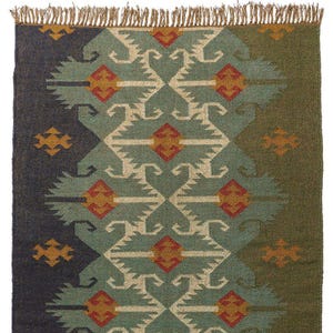 May include: A rectangular rug with a geometric pattern in shades of blue, green, and beige. The design features repeating shapes with orange accents. The rug has a fringed edge and is suitable for home decor.