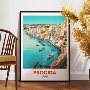 以下が含まれることがあります： イタリアのプロチダの風景を描いた額入りのアートプリント。カラフルな建物が海岸線に沿って並び、ターコイズブルーの海にボートが浮かんでいます。「PROCIDA Italy」の文字が下部にあります。