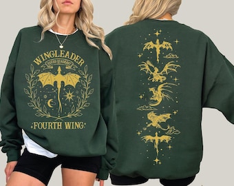 May include: Dark green sweatshirt with gold dragon graphics. The front features a dragon design with the text "WINGLEADER RIDERS QUADRANT FOURTH WING". The back has multiple dragon illustrations. A casual, fantasy-themed apparel item.