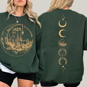 A woman wearing a green sweatshirt with a gold design on the front and back.