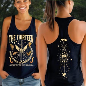 A woman wearing a black tank top with a graphic design on the front and back.