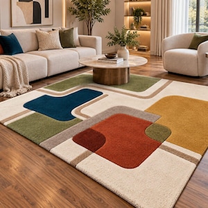 May include: A rectangular area rug featuring a geometric pattern with rounded shapes in shades of cream, deep blue, olive green, mustard yellow, and burnt orange, connected by thin beige lines on a textured, plush surface.