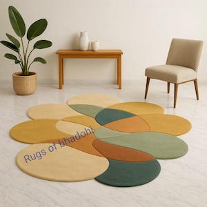 May include: A large, flower-shaped rug in shades of yellow, green, and orange, placed on a white tiled floor. The text "Rugs of bhadohi" is visible on the rug. A wooden table, chair, and potted plant are in the background.