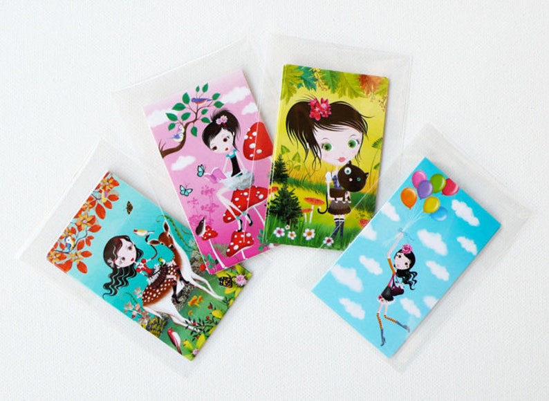 May include: Four colorful cards featuring illustrations of girls in different settings. One card shows a girl with a cat, another shows a girl with a deer, another shows a girl with a mushroom, and the last card shows a girl with balloons.