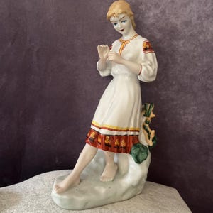 Figurine en porcelaine de l'ère soviétique représentant une fille ukrainienne racontant la bonne aventure sur une marguerite/figurine folklorique de Polonne Maker. Cadeau de collection unisexe.