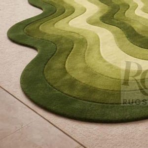 Topographic layered green area rug shown in a spacious classical interior. Wavy organic shape with multiple contour layers in deep and light green tones, resembling terrain elevation. Plush tufted texture, modern artistic floor decor for living rooms or luxury spaces.