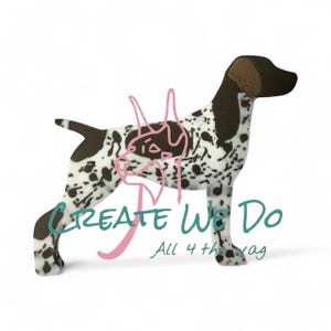 Può includere: Statuetta in legno di cane Pointer tedesco con base bianca e macchie marroni. Il cane ha la testa e la coda marroni. Le parole "CREATE We Do" e "All 4 the wag" sono scritte sull'immagine.