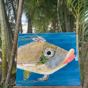 Puede incluir: Una pintura abstracta colorida de un pez con un fondo azul. El pez est&aacute; hecho de diferentes materiales y texturas, incluyendo oro, verde y azul. El ojo del pez es negro y blanco.