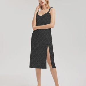 Abito midi in damasco nero con spalline sottili e spacco laterale.