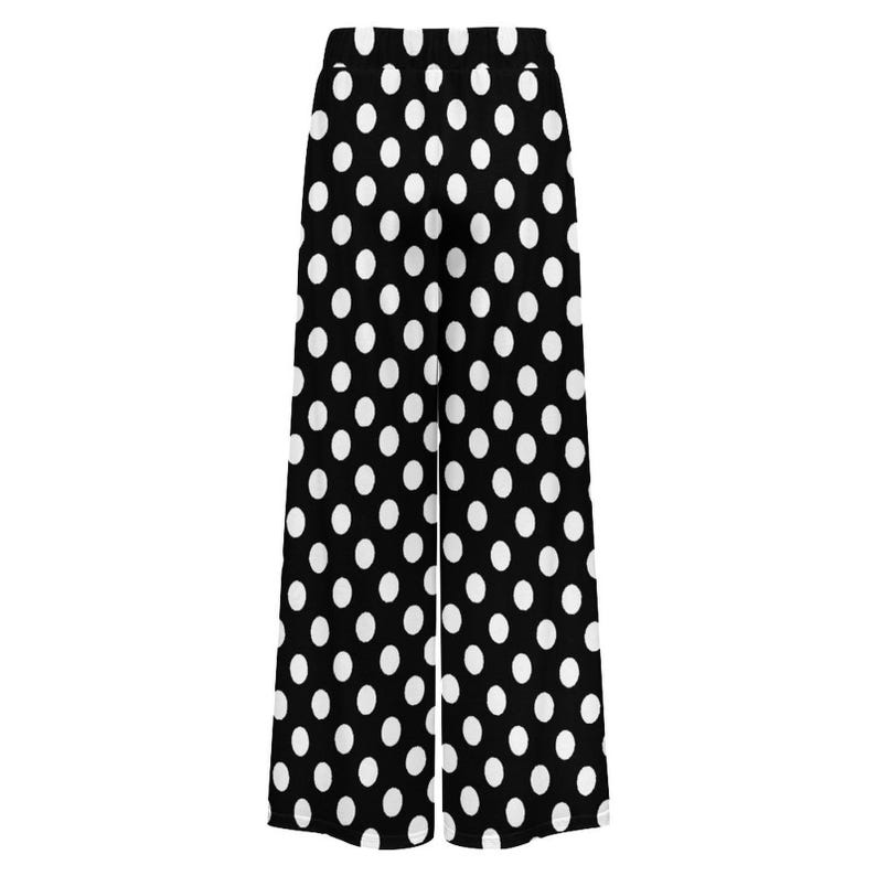 Black wide-leg pants featuring a bold white polka dot pattern. The playful design conveys a retro, stylish vibe suitable for casual or fun occasions.