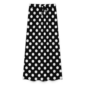 Black skirt with large white polka dots and an adjustable drawstring waistband. The pattern is playful, evoking a retro and stylish vibe.