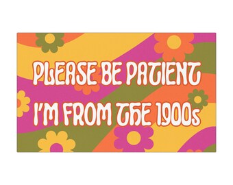 May include: A retro-style sign with the text "PLEASE BE PATIENT I'M FROM THE 1900s" in white, outlined in orange. The background features a colorful pattern of flowers and diagonal stripes in shades of orange, pink, and green.