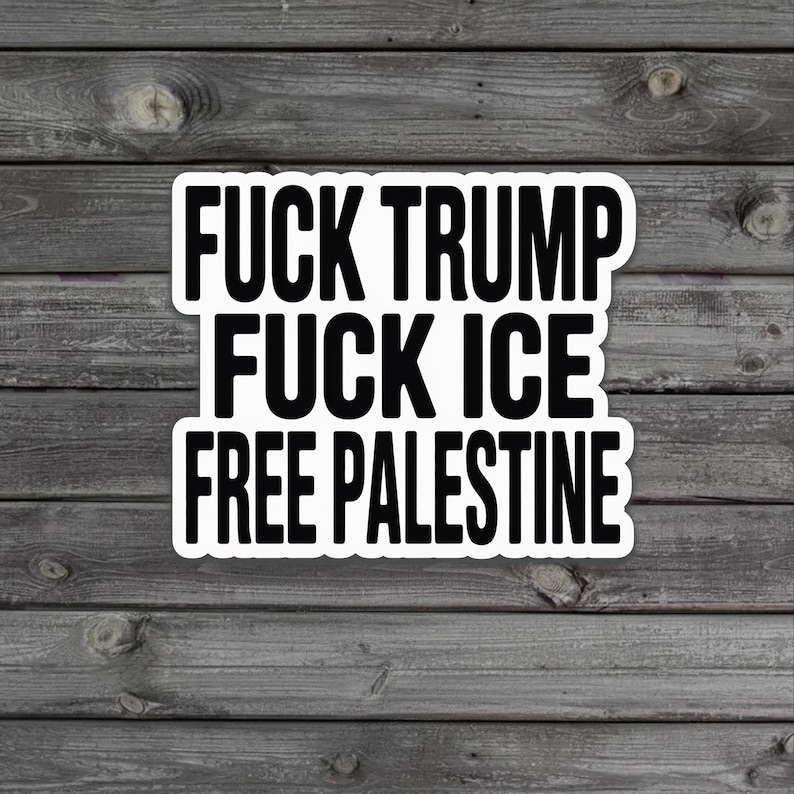 May include: A white sticker with black text that reads "FUCK TRUMP FUCK ICE FREE PALESTINE." The sticker is rectangular with rounded corners and is set against a weathered wood background.