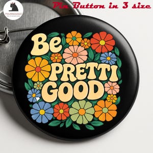 Puede incluir: Un botón negro con la frase "Be PRETTI GOOD" en una fuente retro, rodeado de flores coloridas en naranja, amarillo, rosa, azul y verde. El botón tiene un alfiler metálico en la parte posterior y el texto "Pin Button in 3 size" está en la parte superior.