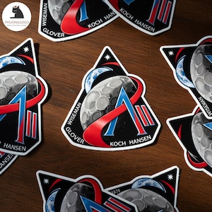 Może przedstawiać: Zestaw trzech ceramicznych kubków z nakrapianym, matowym wykończeniem. Kubki są w odcieniach kremu, jasnoszarym i ciemnoszarym. Każdy kubek ma prosty, minimalistyczny design, idealny do kawy lub herbaty.