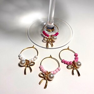Hübsche Bögen & Perlen - Rosa und Weiß perlenbesetzte Wein-Charms mit Schleifen- und Perlenakzent