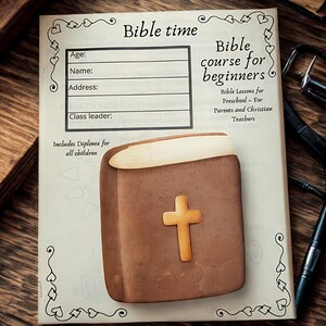 May include: A brown Bible-shaped cookie with a gold cross on top, resting on a page with the text "Bible time" and "Bible course for beginners". The page includes lines for age, name, address, and class leader. The text "Includes Diploma for all children" is also visible.