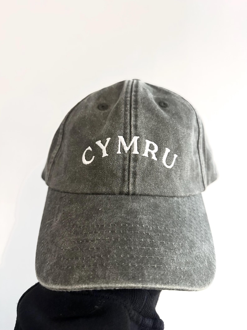 以下が含まれることがあります： 前面に白い刺繍で「CYMRU」の文字が入った、グレーのダメージ加工ベースボールキャップ。 つばがカーブしており、クラウンはしっかりとした構造です。 耐久性のある生地で作られており、ヴィンテージ感があります。