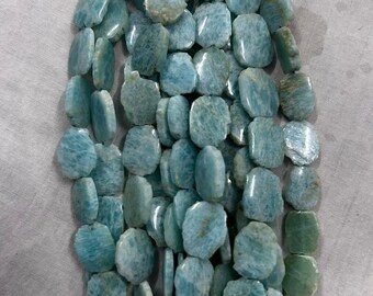 May include: A strand of Amazonite gemstone beads. The beads are a mix of light blue and green hues, with a polished, irregular shape. The beads are strung together, suitable for a necklace or bracelet.