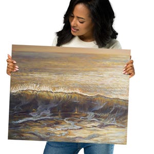 May include: An ocean wave painting in shades of gold, brown, and blue. The artwork depicts a breaking wave with foamy white crests and a textured surface. The painting is held by a person.