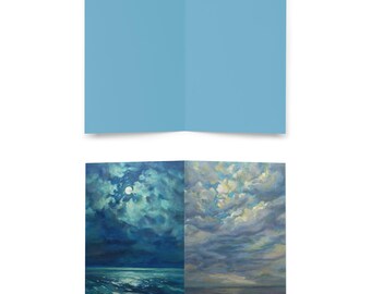 May include: A folded greeting card with a light blue exterior. The interior features a two-panel painting of a seascape with a full moon and a cloudy sky. The painting is signed "Zybo".