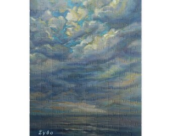 May include: A jigsaw puzzle featuring an impressionistic painting of a cloudy sky over water. The puzzle pieces are arranged to form a complete image with shades of blue, gray, and white. The artist's signature "Zybo" is visible in the bottom left corner.