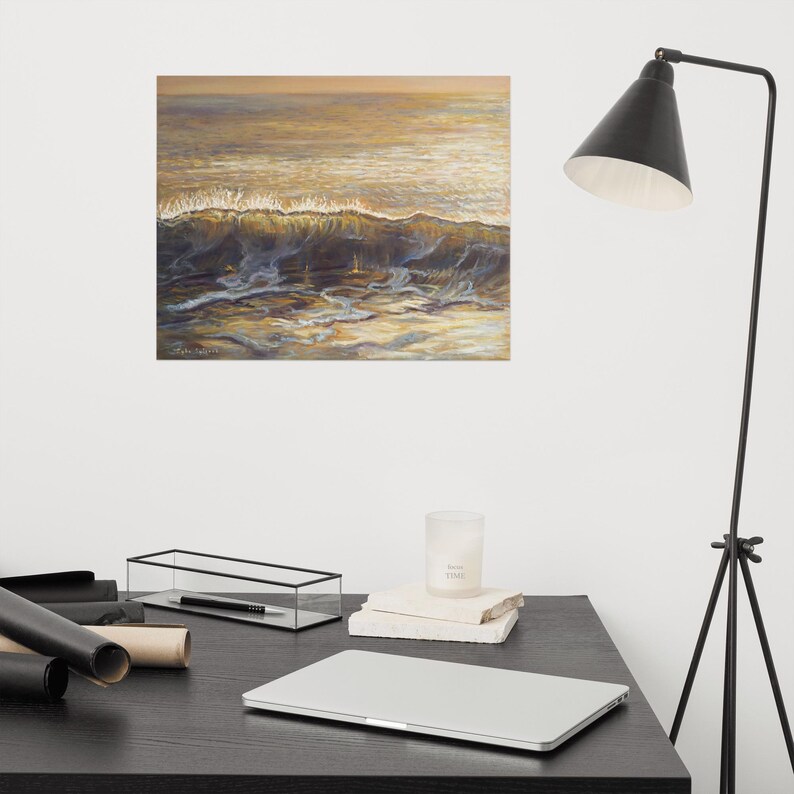 May include: An oil painting of a wave breaking in the ocean. The artwork features shades of gold, brown, and blue, capturing the light reflecting on the water's surface. The painting is displayed on a wall above a desk.