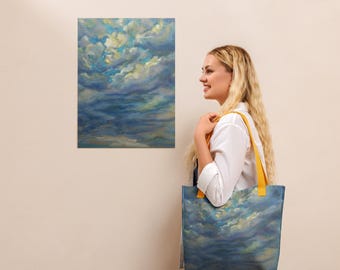 May include: A tote bag and a painting with a cloudy sky design. The tote bag has yellow straps and a blue, yellow, and white cloudy sky design. The painting on the wall has a similar cloudy sky design.
